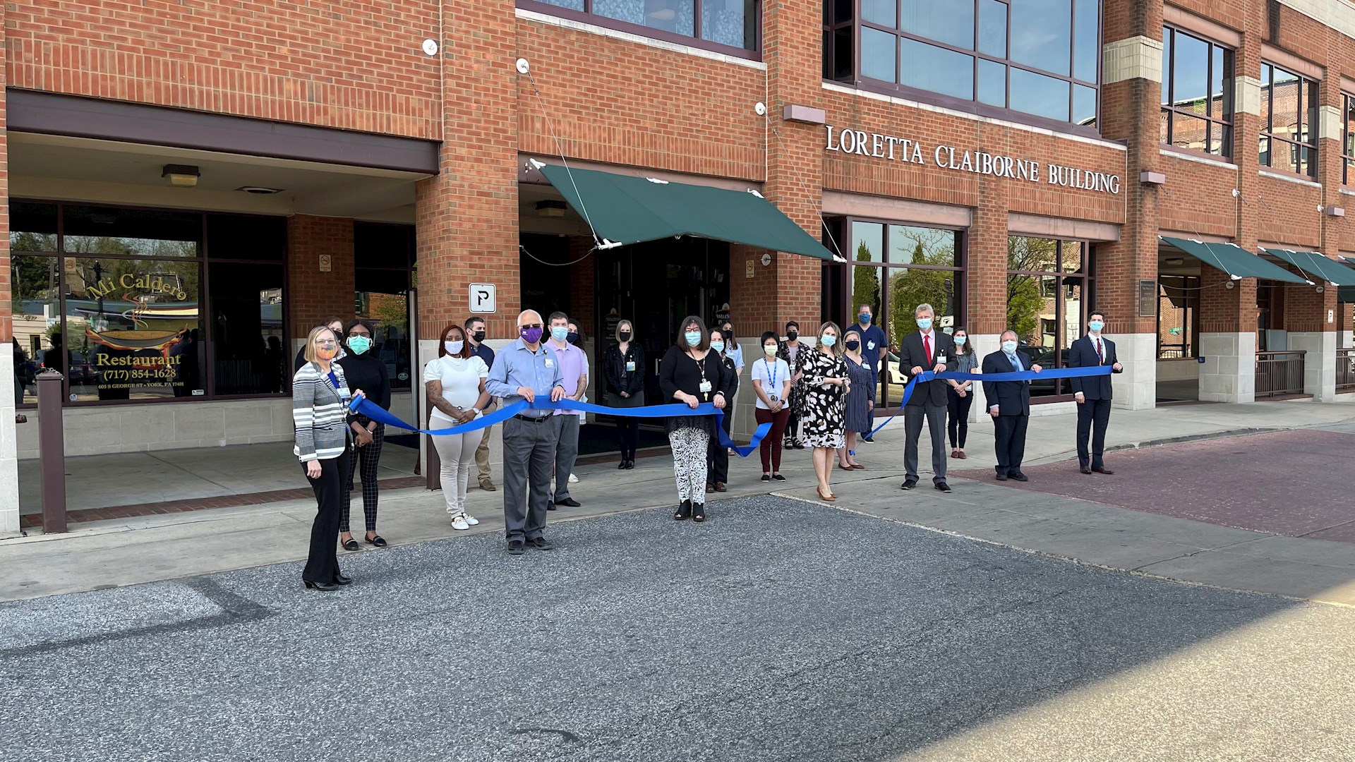 START clinic team members gather outside of the facility to ceremonially cut the ribbon to an innovative one-stop clinic for vulnerable patients with mental health and substance use disorders.