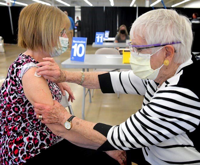 WellSpan Health Volunteer Norma Shue administers the COVID-19 vaccine to a patient at the York County Community Vaccination Clinic in the spring of 2021.
