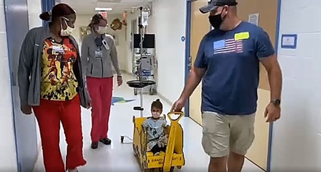 Jaison Michael pulls his daughter, Emma, through the WellSpan York Hospital's pediatric unit, accompanied by two nurses. Emma feels like the "head of her own parade there," her mom, Destiney said.
