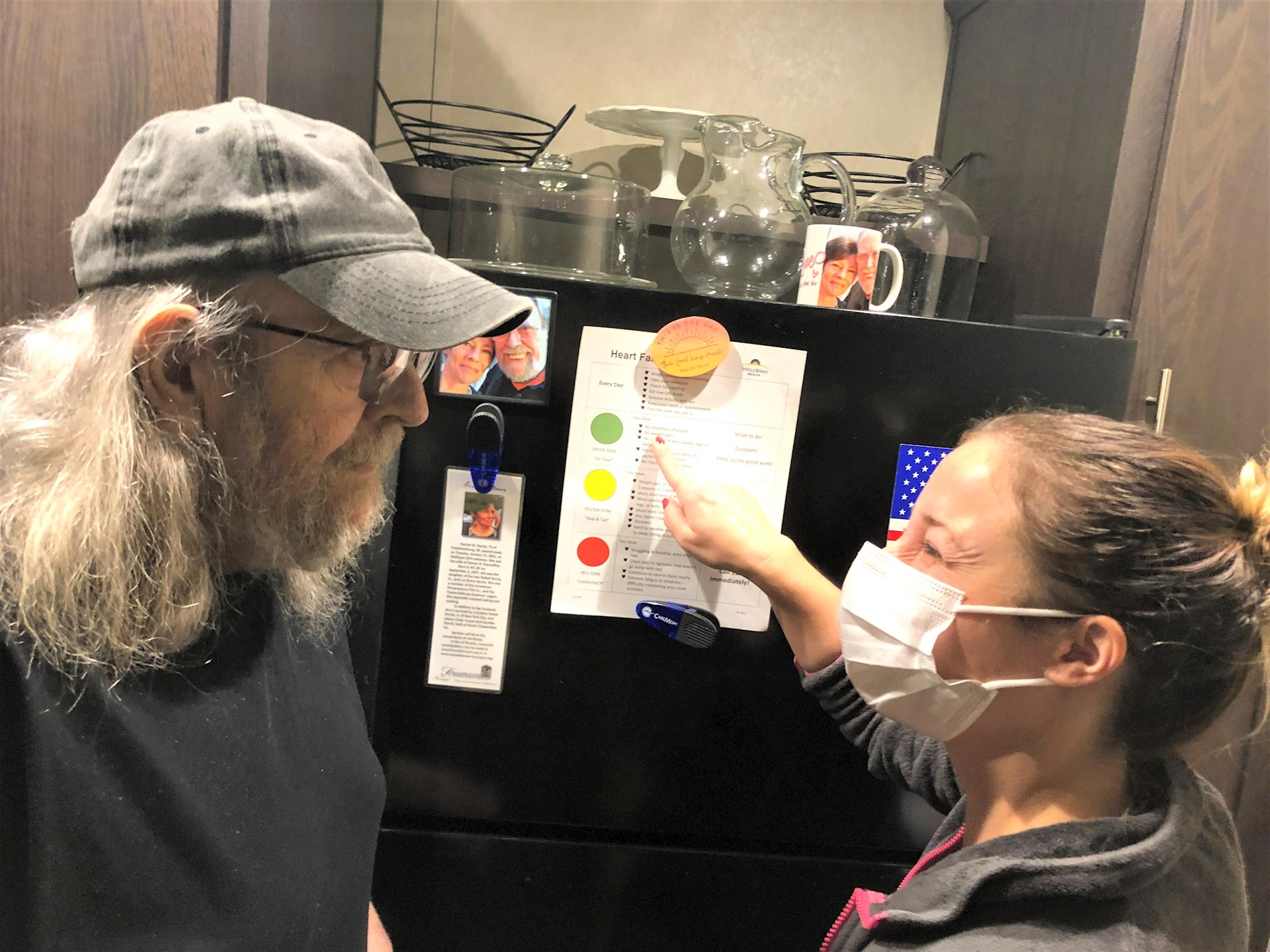 Steve Freundlich and his home health nurse, Jodeane Felty, look at the reminders on his refrigerator for healthy tips on taking care of himself.