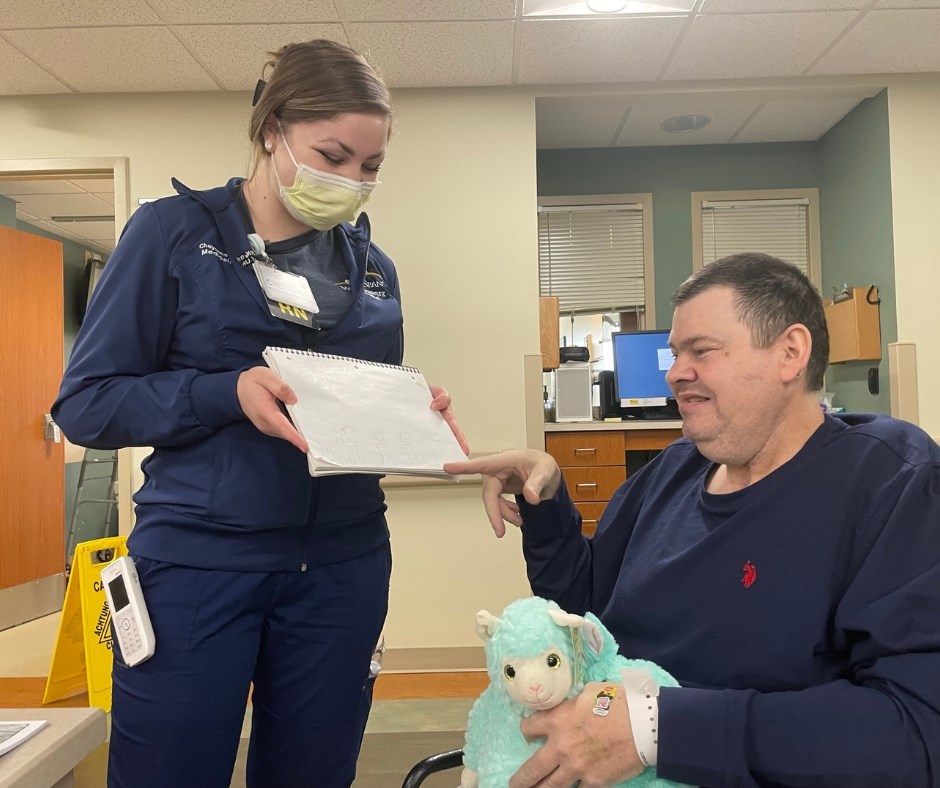 Ricky Dietrich shows nurse Cheyenne Burgett one of the photos he drew for the team at WellSpan Chambersburg Hospital's Medical Surgical Unit during his 93-day stay, after they brought him art supplies.