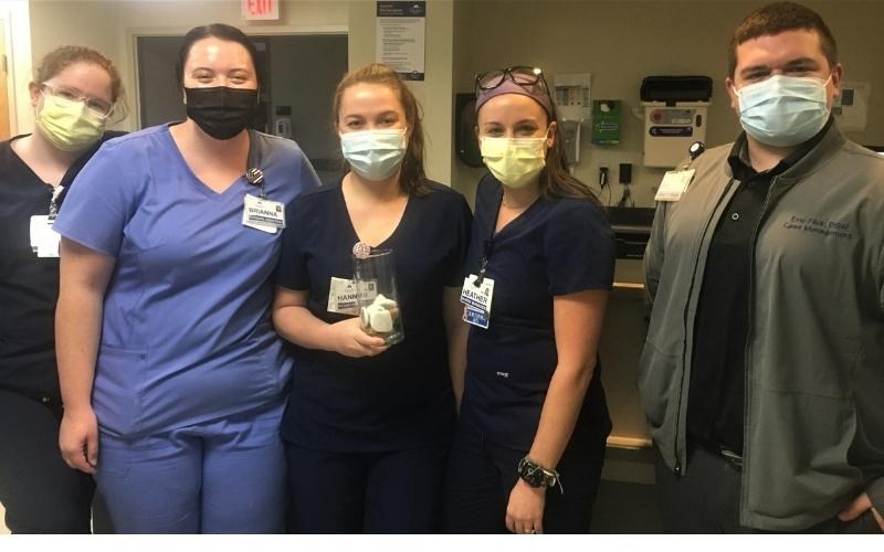 WellSpan Good Samaritan Hospital team members hold a glass jar where they placed stones with the initials of people they memorialized during a special ceremony.