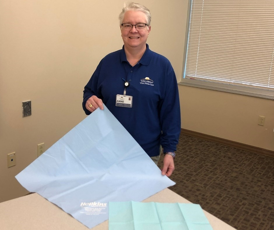 Anne Thomas, a WellSpan physical therapist, holds the reusable antimicrobial pad she suggested WellSpan VNA Home Care workers use. The disposable blue pad she previously used is at lower right.